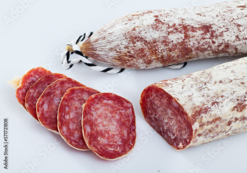 Traditional Catalan dry cured pork sausage Longaniza with sliced pieces on white background