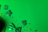 Image of glass with green bee, clover and copy space on green background