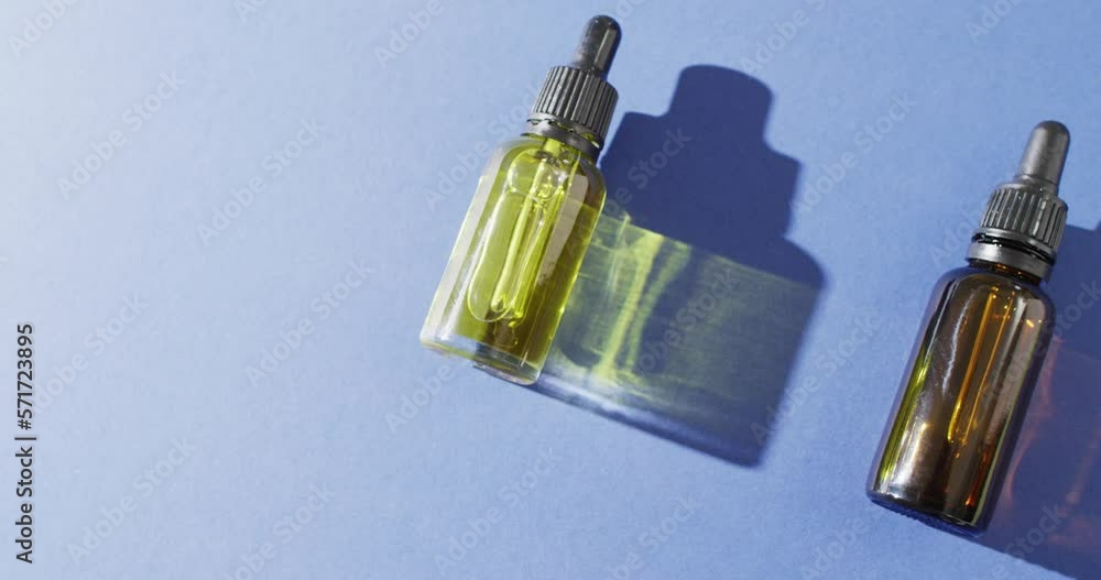 Close up of dropper serum bottles on blue background with copy space Close up of dropper serum bottles on blue background with copy space