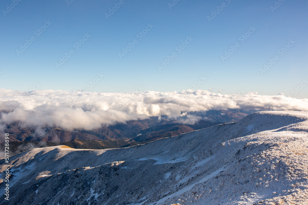 idyllic mountain landscape, with peaks covered by snow and fog, early spring