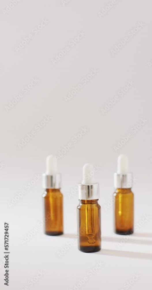 Vertical video of dropper serum bottles on white background with copy space Vertical video of dropper serum bottles on white background with copy space