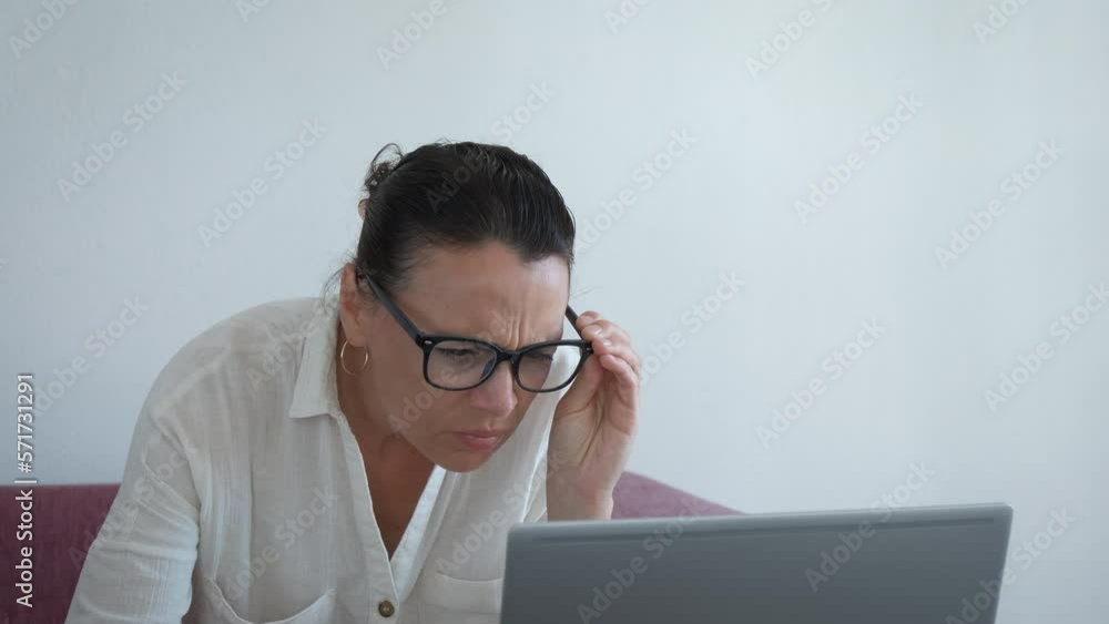 Freelancer squinting eyes. A view of freelancer in glasses try to squinting her eyes for better vision by computer. Freelancer squinting eyes. A view of freelancer in glasses try to squinting her eyes for better vision by computer.