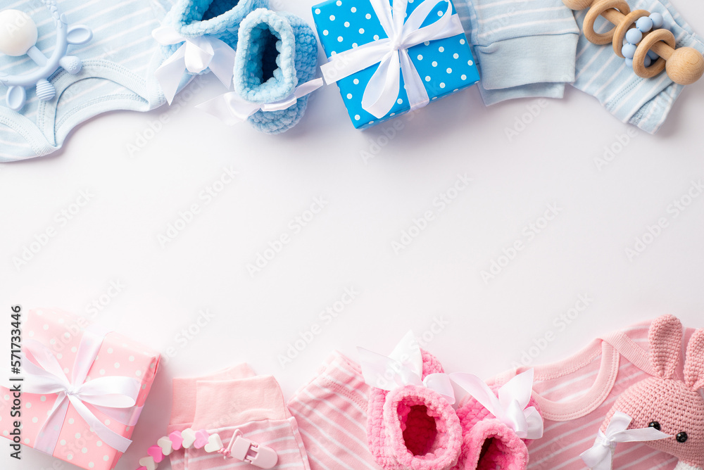 Gender reveal party concept. Top view photo of pink and blue infant clothes shirts pants knitted booties gift boxes bunny rattle toy and teether chain on isolated white background with copyspace - obrazy, fototapety, plakaty 