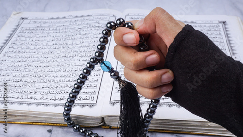 Islam holy book of Muslims, the Quran. Holy Al Quran and prayer beads or tasbih on marble background