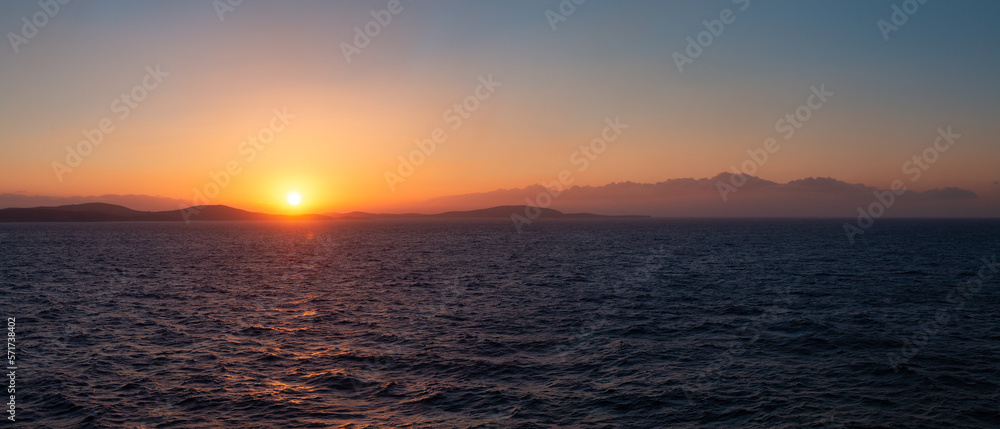 Obraz premium Rocky Island on Mediterranean Sea. Rinia near Mikonos, Greece, Europe. Nature Background Panorama. Sunrise Sky