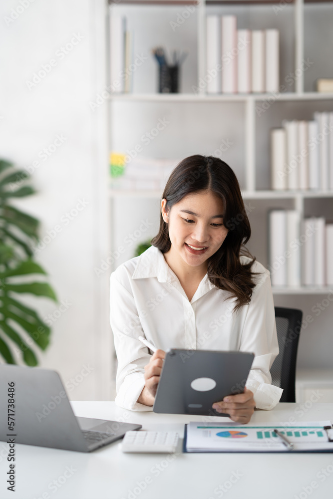 Young smart businesswoman writing her ideas on digital tablet while sitting in the modern office room. Young smart businesswoman writing her ideas on digital tablet while sitting in the modern office room.