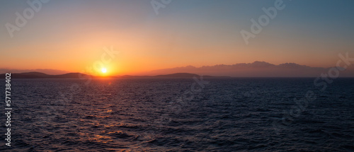 Fototapeta Naklejka Na Ścianę i Meble -  Rocky Island on Mediterranean Sea. Rinia near Mikonos, Greece, Europe. Nature Background Panorama. Sunrise Sky