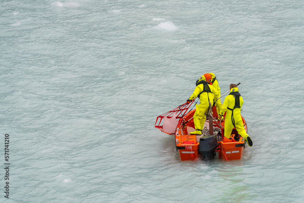 Crew in small power boat collecting iceberg by Amalia Glacier in Patagonia and Chile