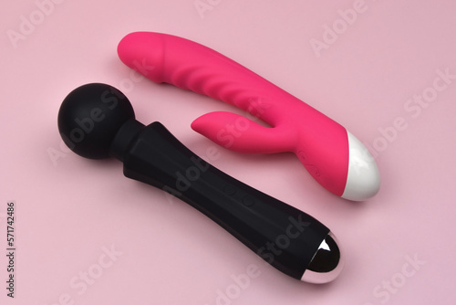 Black and fuchsia vibrators on a pink background, dildos prostate massager, clitoris stimulator, g-spot vibrators, accessories for adult sexual games, sex toys for adults photo