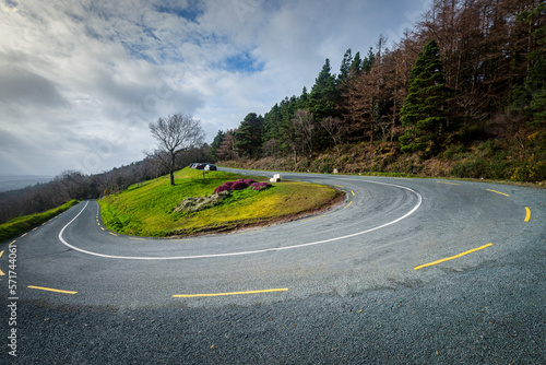 Hair pin bend on mountain country road on a bright cloudy day in Ireland.