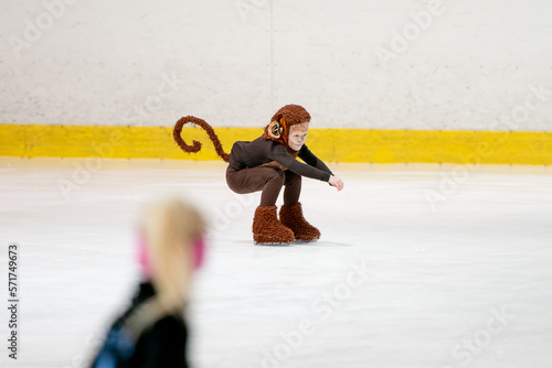 figure skating of a small child in a monkey costume. Preparing for the performance on the ice photo