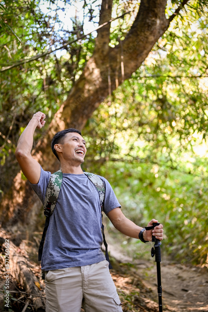 Excited and active Asian male trekker raising hand, celebrating success, arrived at the destination. Excited and active Asian male trekker raising hand, celebrating success, arrived at the destination.