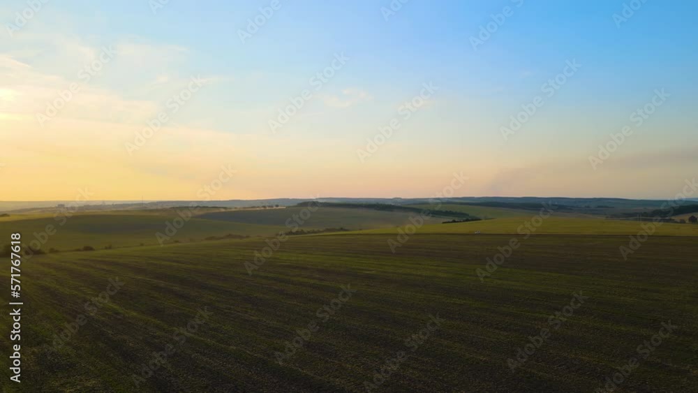 Aerial landscape view of green cultivated agricultural fields with growing crops on bright summer evening Aerial landscape view of green cultivated agricultural fields with growing crops on bright summer evening