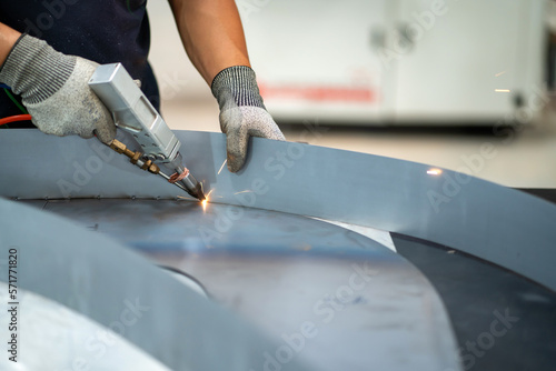 Steel handles are welded with argon-arc welding. Man wearing argon-arc welding gloves Industrial welder welding with argon machine.