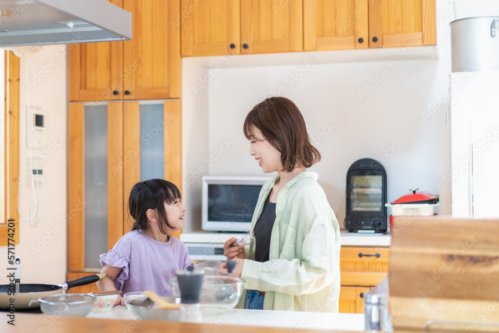 お母さんと一緒に料理をする小さな女の子 お母さんと一緒に料理をする小さな女の子