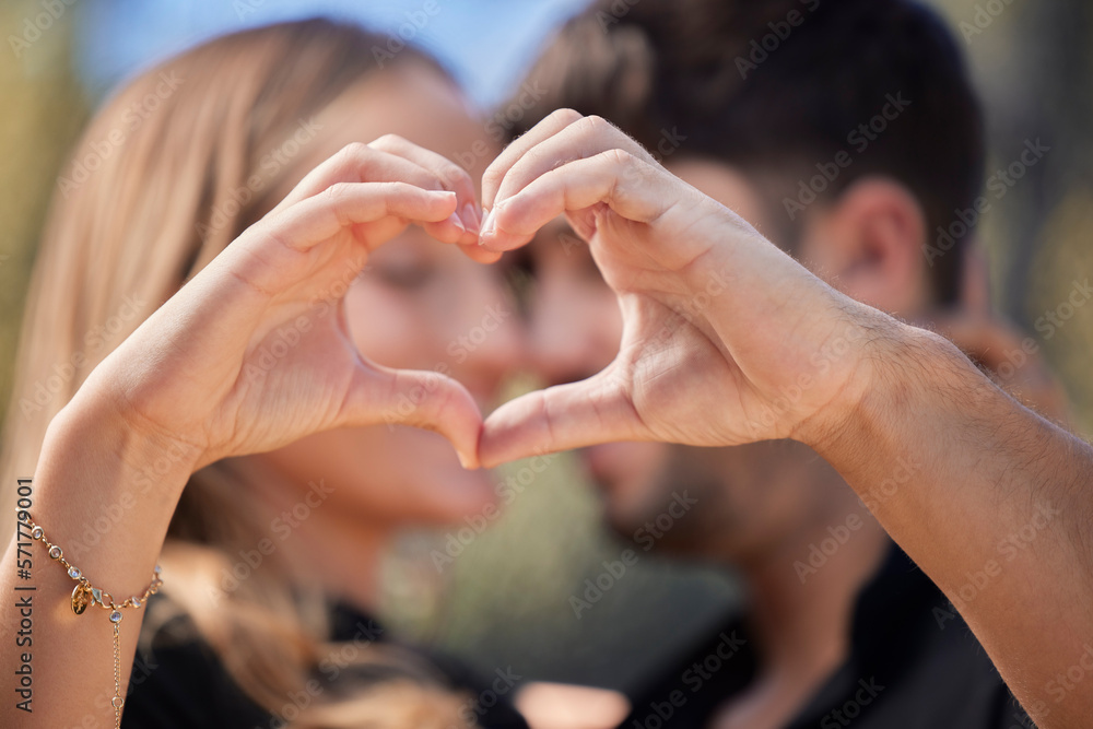 Fototapeta premium Happy, heart shape and couple hugging in nature while on romantic date for valentines day or anniversary. Intimacy, affection and young man and woman embracing with love hand sign or gesture together
