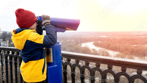 Photo a boy looks through a telescope on the observation deck