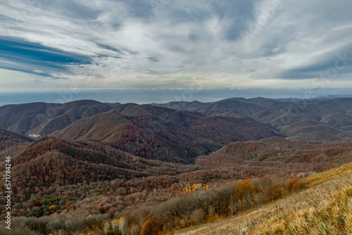 View of the mountain range under a cloudy sky. Mountain landscape with beautiful Caucasian nature. Panoramic view of the Caucasus mountains. Landscape of a mountain range on an autumn morning.