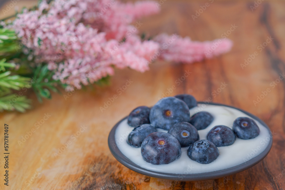 blueberries with yogurt on a black plate blueberries with yogurt on a black plate