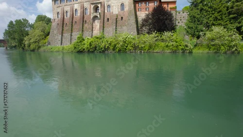 Aerial shot over a lake next to a stone building in Cassano d´adda in Lombardy, Italy. photo