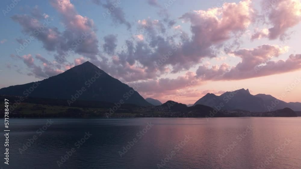 Low flight over the water surface of a mountain lake. Towering alpine mountains in the distance. Romantic Sunset in Switzerland Low flight over the water surface of a mountain lake. Towering alpine mountains in the distance. Romantic Sunset in Switzerland