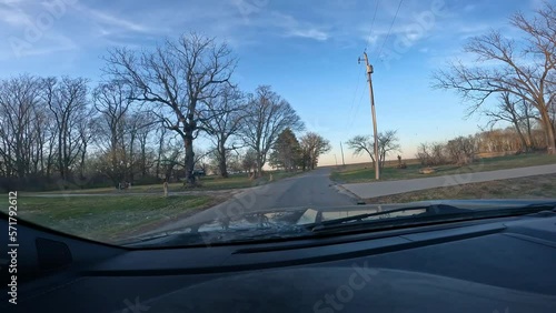 Point of view - driving on rural country road past a few homes and  empty fields; in late Autumn; Midwest USA photo