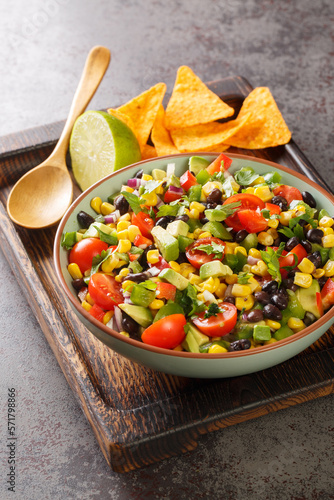 Cowboy texac caviar is a traditional American salad made with black beans, garlic, onion, bell peppers, jalapenos, corn, coriander closeup in the bowl on the table. Vertical photo