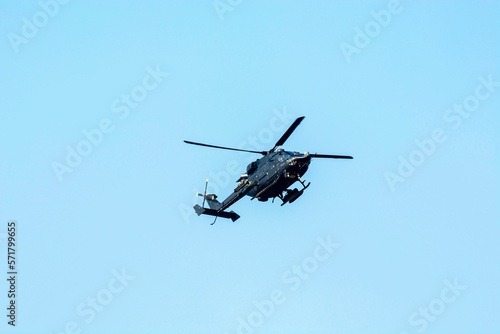Fototapeta Naklejka Na Ścianę i Meble -  Combat helicopter is flying against isolated blue sky. Combat helicopter attack enemy.