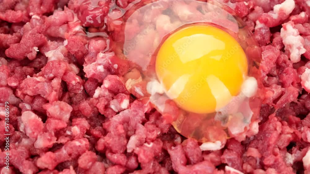 Chef add raw egg in raw minced meat. Cooking meatballs