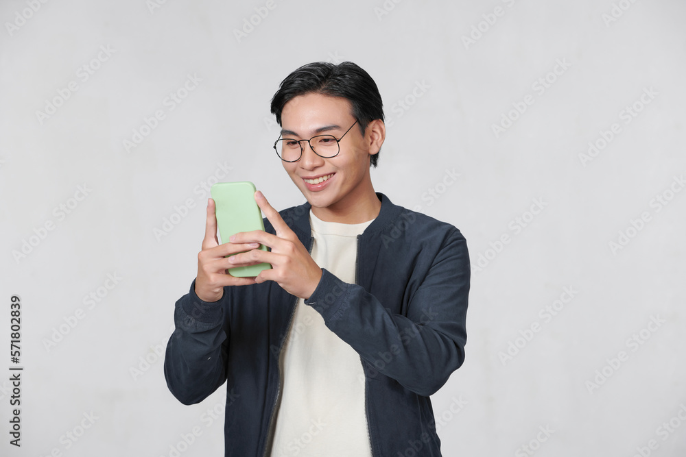 Smart casual asian man using smartphone in studio background Smart casual asian man using smartphone in studio background