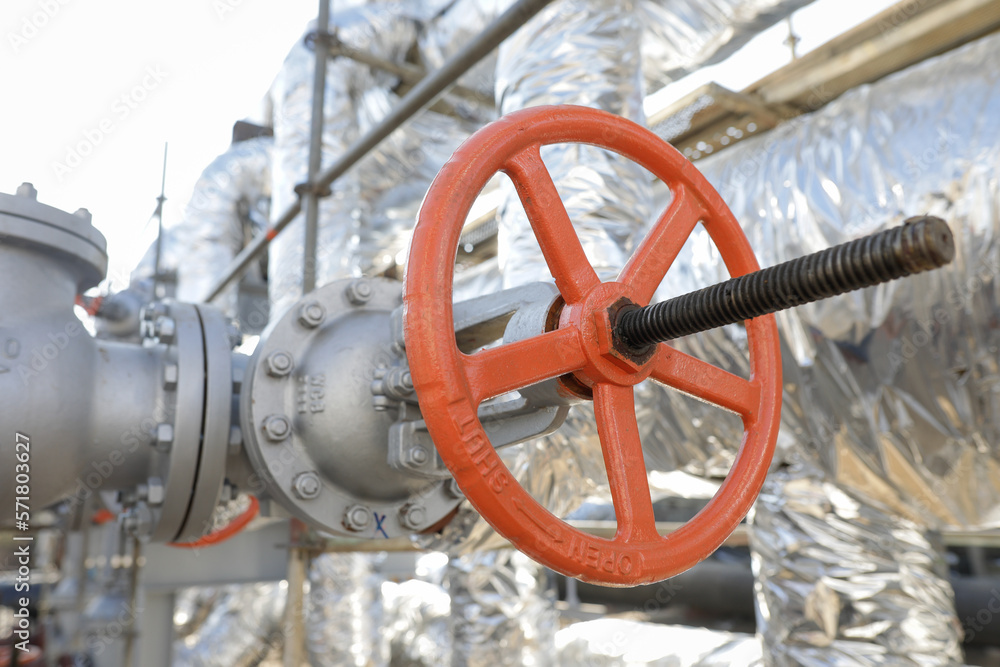 Shallow depth of field details with a metallic pipe valve used to open or close the hot water debit inside a big pipeline. Shallow depth of field details with a metallic pipe valve used to open or close the hot water debit inside a big pipeline.