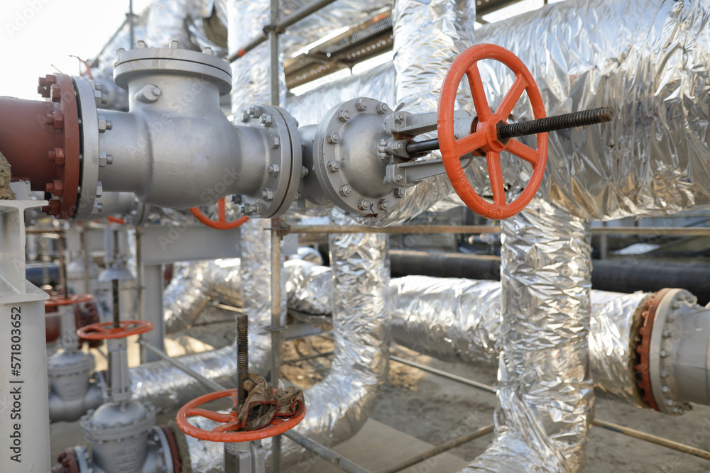 Shallow depth of field details with a metallic pipe valve used to open or close the hot water debit inside a big pipeline. Shallow depth of field details with a metallic pipe valve used to open or close the hot water debit inside a big pipeline.
