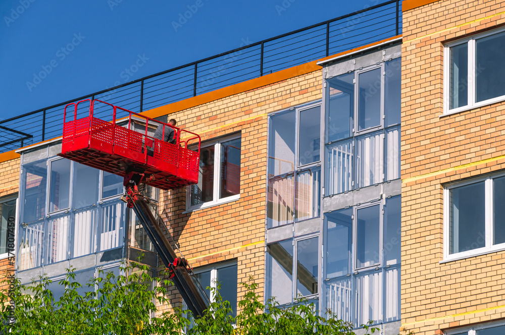 Construction lift for finishing works at height. A construction worker