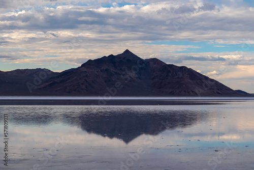 Scenic view of beautiful mountains reflecting in lake of Bonneville Salt Flats at sunset, Wendover, Western Utah, USA, America. Looking at summits of Silver Island Mountain range. Romantic atmosphere