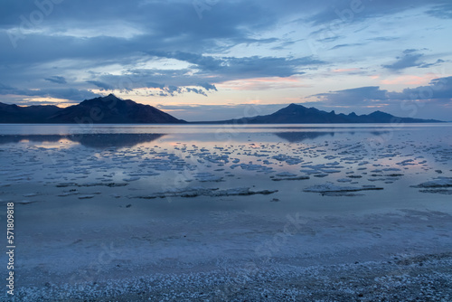 Scenic view of beautiful mountains reflecting in lake of Bonneville Salt Flats at sunset, Wendover, Western Utah, USA, America. Looking at summits of Silver Island Mountain range. Romantic atmosphere