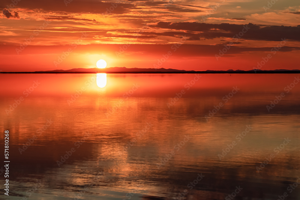 Naklejka premium Scenic sunrise view of beautiful water reflections in lake of Bonneville Salt Flats, Wendover, Western Utah, USA, America. Dreamy clouds mirroring on the water surface creating romantic atmosphere