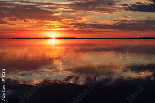 Scenic sunrise view of beautiful water reflections in lake of Bonneville Salt Flats, Wendover, Western Utah, USA, America. Dreamy clouds mirroring on the water surface creating romantic atmosphere