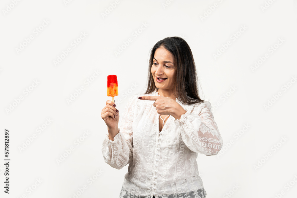 happy asian woman holding ice pop, a lolly frozen stick with mango yellow, fruit ice cream