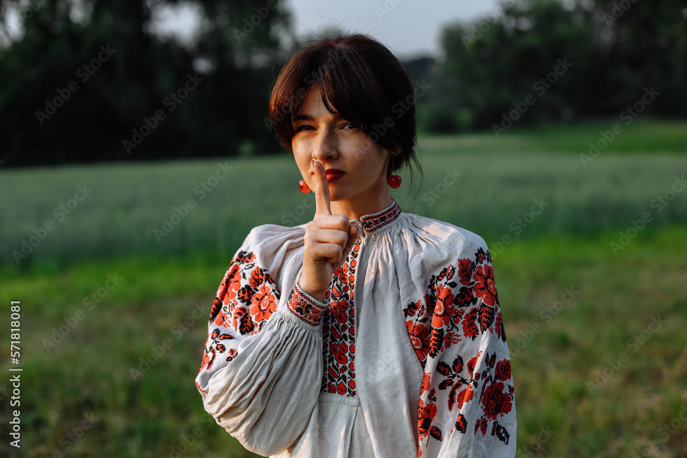 A girl in a national dress on a background of greenery in a field on a sunny day A girl in a national dress on a background of greenery in a field on a sunny day
