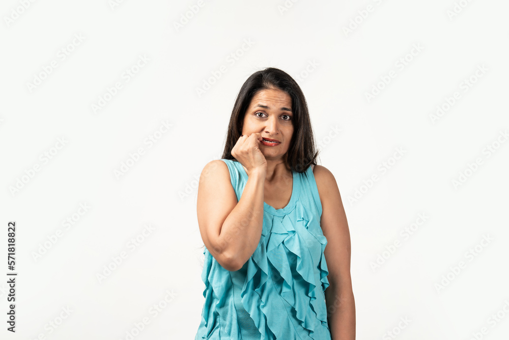 Mid aged Indian woman isolated on white background biting fingernails, nervous and very anxious.