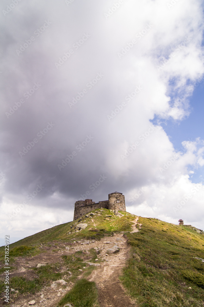 Stone medieval castle on cliff landscape photo. Beautiful nature scenery photography with cloudy sky on background. Ambient light. High quality picture for wallpaper, travel blog, magazine, article