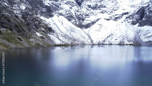 Czarny Staw pod Rysamy or Black Pond lake near the Morskie Oko Snowy Mountain Hut in Polish Tatry mountains, drone view, Zakopane, Poland. Aerial view shot of beautiful green hills and mountains in