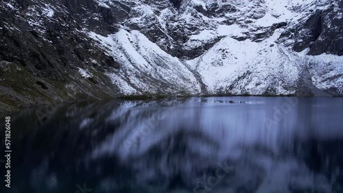 Czarny Staw pod Rysamy or Black Pond lake near the Morskie Oko Snowy Mountain Hut in Polish Tatry mountains, drone view, Zakopane, Poland. Aerial view shot of beautiful green hills and mountains in