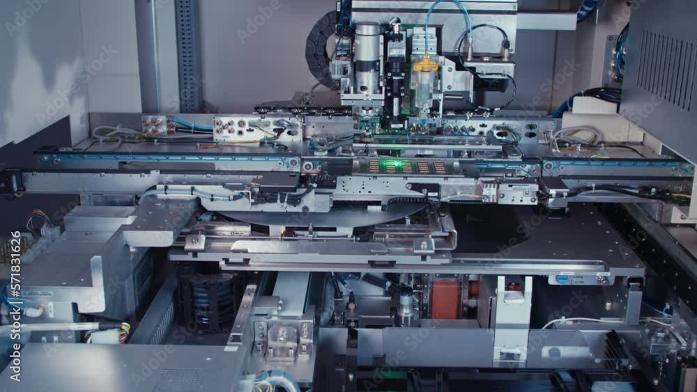Automated SMT machine placing electronic components on a board Automated SMT machine placing electronic components on a board