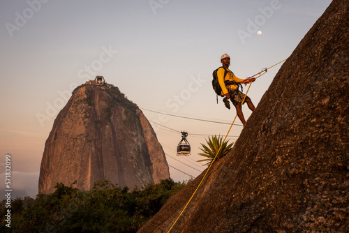 Man rappelling in Morro da Urca with Sugar Loaf Mountain on the back photo