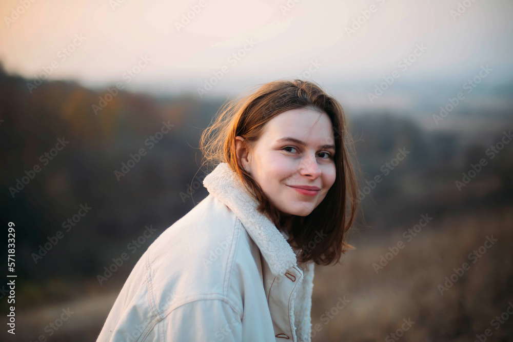 Portrait of a beautiful young woman in warm clothes during sunset Portrait of a beautiful young woman in warm clothes during sunset