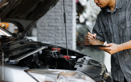 Auto mechanic working in garage. Repair service.
