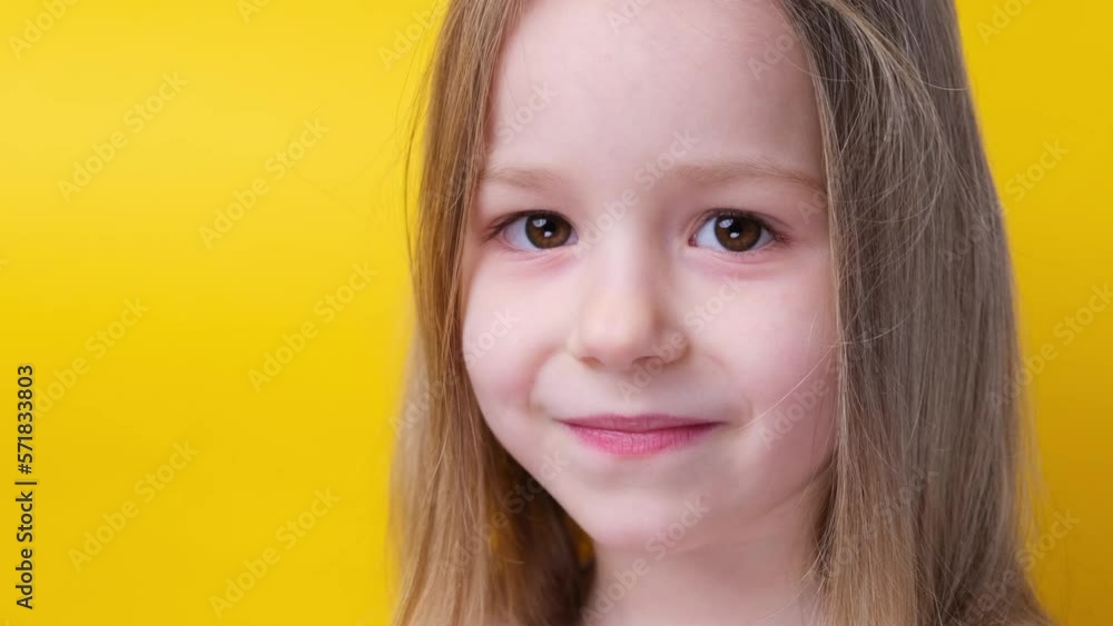 Close up smiling little girl before haircut Look at the camera scissors in hand Close up smiling little girl before haircut Look at the camera scissors in hand
