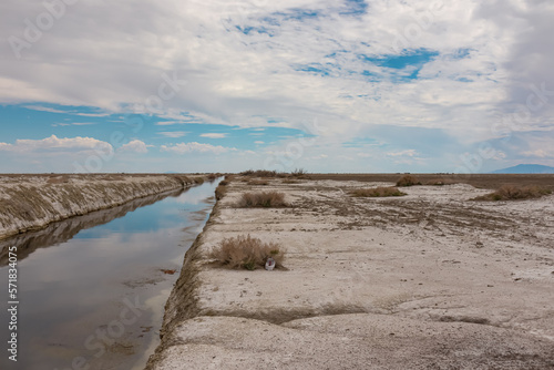 Scenic view of the canals of Bonneville Salt Flats in Wendover  Western Utah  USA  America. Clouds appear as beautiful water reflection in the river. Barren salt desert landscape near Salt Lake City