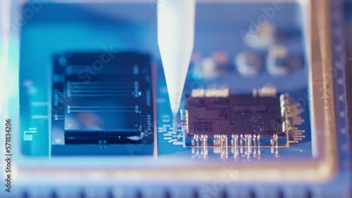 Macro shot of wire bonder connecting wires to a microchip at high speed